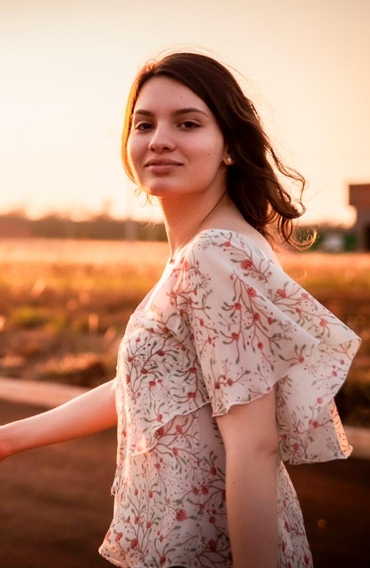 Yasmin em um campo ao pôr do sol